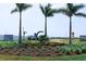 Community entrance featuring lush landscaping, palm trees, and signage indicating paired and single-Gathering villas at 655 Maldives Trl, Sarasota, FL 34234