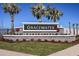 Gracewater community entrance sign showcasing stone details, vibrant flowers, and palm tree accents at 655 Maldives Trl, Sarasota, FL 34234
