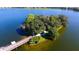 Aerial view of an island with walking path and lush trees surrounded by a lake at 6552 Moorings Point Cir # 201, Lakewood Ranch, FL 34202
