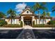Exterior of community clubhouse with palm trees and brick walkway, and ample parking at 6552 Moorings Point Cir # 201, Lakewood Ranch, FL 34202