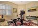 Bright exercise room features stationary bike, weight bench, TV, and colorful rug at 6552 Moorings Point Cir # 201, Lakewood Ranch, FL 34202