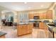 Bright kitchen features wood cabinets, stainless steel appliances, granite countertops, and tile floors at 6552 Moorings Point Cir # 201, Lakewood Ranch, FL 34202