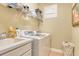 Well-equipped laundry room with sink, washer, dryer, and convenient overhead shelving at 6552 Moorings Point Cir # 201, Lakewood Ranch, FL 34202