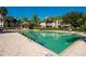 Community swimming pool with palm trees, landscaping and lounge chairs at 6552 Moorings Point Cir # 201, Lakewood Ranch, FL 34202
