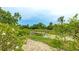 Lush backyard view featuring gravel walkway, a verdant pond view, and tropical foliage at 7126 Southgate Ct, Sarasota, FL 34243