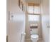 Powder room with a neutral color palette, toilet, small window with blinds, and coastal decor at 7126 Southgate Ct, Sarasota, FL 34243