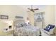 Cozy bedroom with tropical decor, a ceiling fan, and a window with decorative curtains at 7126 Southgate Ct, Sarasota, FL 34243