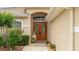 A grand entryway featuring double wood doors with glass inserts and manicured landscaping at 7126 Southgate Ct, Sarasota, FL 34243