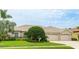Beautiful home exterior showcasing a well-kept lawn, manicured landscaping, and a spacious three-car garage at 7126 Southgate Ct, Sarasota, FL 34243