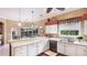 Updated kitchen with a breakfast bar, white cabinets, and backyard views from the sink window at 7126 Southgate Ct, Sarasota, FL 34243
