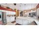 Spacious kitchen with white cabinets, stainless steel refrigerator, and breakfast bar seating at 7126 Southgate Ct, Sarasota, FL 34243