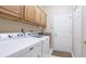 Well lit laundry room with built in cabinets and modern washer and dryer at 7126 Southgate Ct, Sarasota, FL 34243
