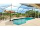 Enclosed pool with lush landscaping featuring outdoor seating and a large umbrella at 7126 Southgate Ct, Sarasota, FL 34243