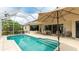 Screened-in pool area featuring a spacious patio with ample seating and a large patio umbrella for shade at 7126 Southgate Ct, Sarasota, FL 34243