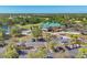 Aerial view of the clubhouse with a green roof, parking lot, lake, and golf course in a beautiful setting at 7160 Cedar Hollow Cir, Bradenton, FL 34203