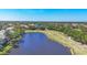 Aerial view of a lush golf course bordering a dark blue lake with homes in the distance at 7160 Cedar Hollow Cir, Bradenton, FL 34203