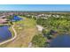 Expansive aerial view of a golf course with sand traps and blue lakes and residential homes nearby at 7160 Cedar Hollow Cir, Bradenton, FL 34203