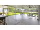 A covered outdoor patio with tables and views of the tennis court at 7160 Cedar Hollow Cir, Bradenton, FL 34203