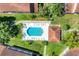 Overhead view of a sparkling pool with lounge chairs, lush landscaping, and surrounding greenery at 7160 Cedar Hollow Cir, Bradenton, FL 34203