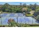 Aerial view of multiple pristine tennis courts with beautiful landscaping and forest in the background at 7160 Cedar Hollow Cir, Bradenton, FL 34203