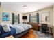 Bright bedroom with hardwood floors, a large dresser, workspace, and two windows at 777 51St N Ave, St Petersburg, FL 33703