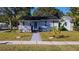 Charming light blue single-story home featuring a well-manicured lawn and inviting front porch at 777 51St N Ave, St Petersburg, FL 33703