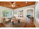 Inviting living room with wood ceiling, natural light, ceiling fan, and built-in bookshelves at 777 51St N Ave, St Petersburg, FL 33703