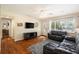 Cozy living room with hardwood floors, dark leather sofas, and natural light from windows at 777 51St N Ave, St Petersburg, FL 33703