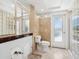 A bathroom featuring a toilet, mirrors, tan tile, and glass-blocked window panels at 7779 Holiday N Dr, Sarasota, FL 34231
