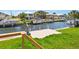 Waterfront view of a canal with multiple boat lifts and well-maintained green lawn at 7779 Holiday N Dr, Sarasota, FL 34231