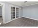 The room has glass french doors, carpet, and neutral paint at 800 S Blvd Of The Presidents # 5, Sarasota, FL 34236