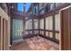 Inviting courtyard featuring brick pavers, brown siding and a stylish green front door with glass paneled entryways at 800 S Blvd Of The Presidents # 5, Sarasota, FL 34236