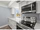 Modern kitchen with stainless steel appliances and light countertops, with a view to the outdoors at 800 S Blvd Of The Presidents # 5, Sarasota, FL 34236