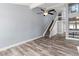 Open living room showcasing gray walls, a ceiling fan, stairs to the upper level and wood-look flooring at 800 S Blvd Of The Presidents # 5, Sarasota, FL 34236