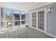 Sun-filled room featuring large windows, glass french doors, and neutral carpet at 800 S Blvd Of The Presidents # 5, Sarasota, FL 34236