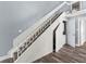 Staircase featuring under-stair storage, white railings, and a view into a utility closet at 800 S Blvd Of The Presidents # 5, Sarasota, FL 34236