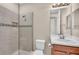 Bathroom featuring a tiled shower with glass doors, a commode and a single sink vanity at 8273 Shooting Star Rd, Sarasota, FL 34241