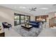 Inviting living room features a plush blue sofa, stylish rug, and sliding glass doors to the pool at 8273 Shooting Star Rd, Sarasota, FL 34241