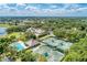 Aerial view of a community with tennis courts, golf course, pool, clubhouse, and lush greenery under a partly cloudy sky at 8525 54Th Avenue E Cir, Bradenton, FL 34211