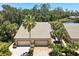 Aerial view of home with lush tropical landscaping, tile roof, and brick driveway at 8525 54Th Avenue E Cir, Bradenton, FL 34211