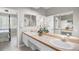 Spacious bathroom featuring dual sinks, a large mirror, and a well-lit vanity area with neutral tones and sliding mirror closet doors at 8525 54Th Avenue E Cir, Bradenton, FL 34211