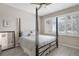 Comfortable bedroom featuring a canopy bed, ceiling fan, and a bright window with plantation shutters at 8525 54Th Avenue E Cir, Bradenton, FL 34211