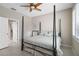 Cozy bedroom featuring a four-poster bed, ceiling fan, and neutral decor with an open door at 8525 54Th Avenue E Cir, Bradenton, FL 34211