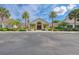 Attractive clubhouse with lush landscaping, a paved entrance, and palm trees at 8525 54Th Avenue E Cir, Bradenton, FL 34211