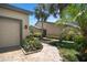 Home exterior featuring landscaped pathway leading to the front door with lush greenery and palm trees at 8525 54Th Avenue E Cir, Bradenton, FL 34211