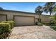 Home exterior featuring a brick driveway leading to a spacious two-car garage, adorned with manicured landscaping at 8525 54Th Avenue E Cir, Bradenton, FL 34211