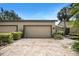 Home exterior with brick driveway leading to a spacious two-car garage with manicured landscaping at 8525 54Th Avenue E Cir, Bradenton, FL 34211