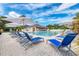Luxurious swimming pool with comfortable lounge chairs, umbrellas, and a poolside pavilion for ultimate relaxation at 8525 54Th Avenue E Cir, Bradenton, FL 34211