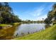 Scenic water view with lush landscaping and blue sky, perfect for relaxation and enjoying the natural surroundings at 8525 54Th Avenue E Cir, Bradenton, FL 34211