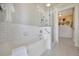Bathroom featuring a tub and shower with subway tile, glass surround, and an attached changing area at 880 N Shore Dr, Anna Maria, FL 34216